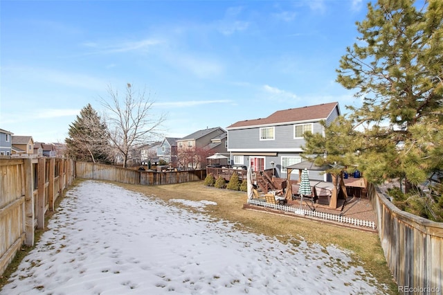 yard covered in snow featuring a deck