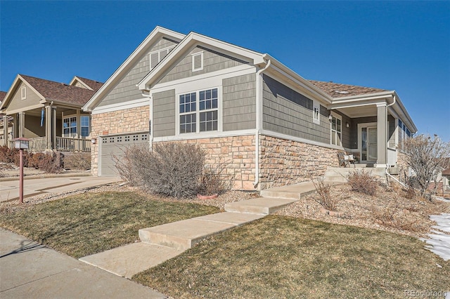 view of front of property with a porch, a garage, and a front lawn