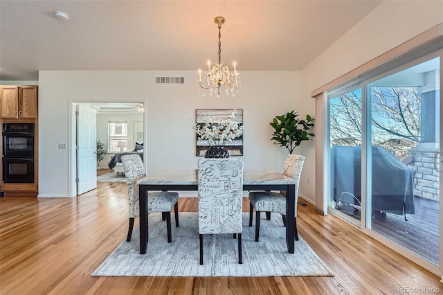 dining space with a chandelier and light wood-type flooring