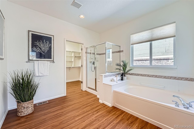 bathroom featuring hardwood / wood-style flooring and shower with separate bathtub