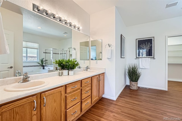 bathroom with vanity, hardwood / wood-style floors, and shower with separate bathtub