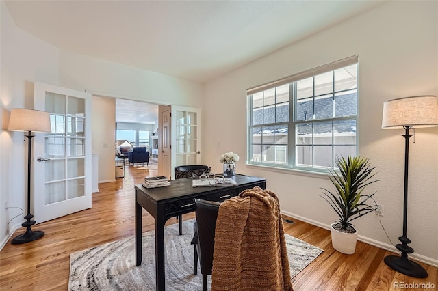 office area with french doors and light hardwood / wood-style flooring