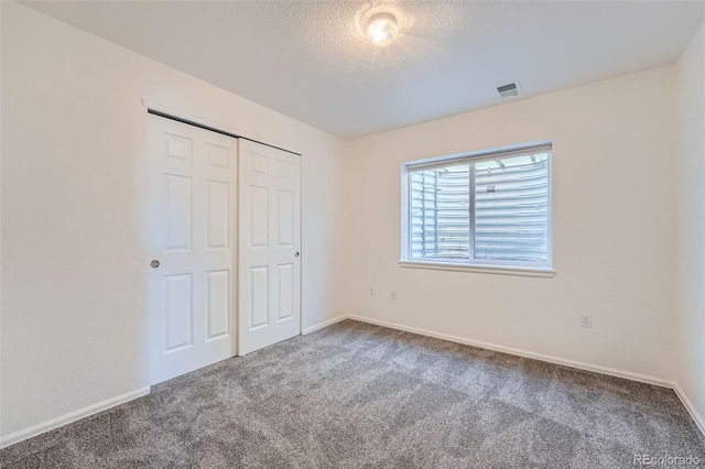 unfurnished bedroom featuring carpet floors, a closet, and a textured ceiling