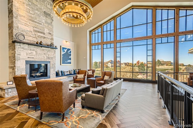 living room with parquet floors, a fireplace, a chandelier, and a high ceiling