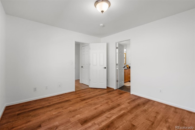 4185 Red Rock Dr, Larkspur, CO 80118 - unfurnished bedroom with baseboards, wood finished floors, and connected bathroom