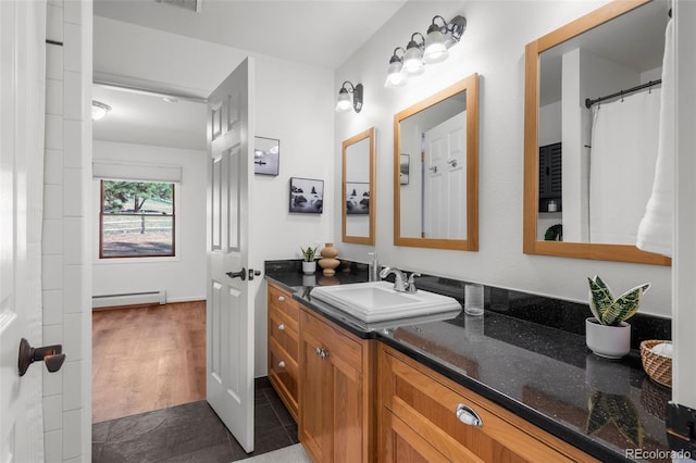 4185 Red Rock Dr, Larkspur, CO 80118 - full bathroom with baseboard heating, vanity, and tile patterned flooring