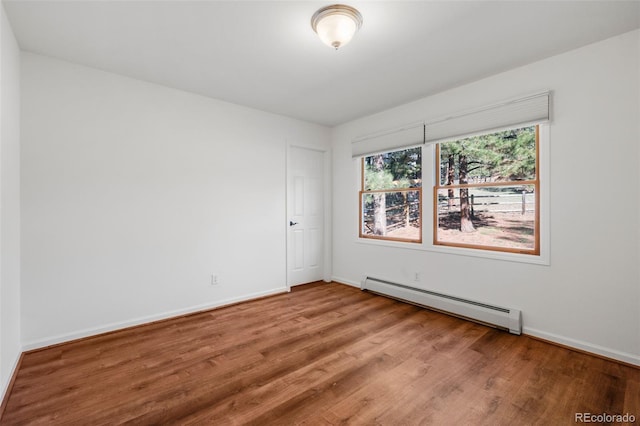 4185 Red Rock Dr, Larkspur, CO 80118 - unfurnished room featuring a baseboard radiator, wood finished floors, and baseboards