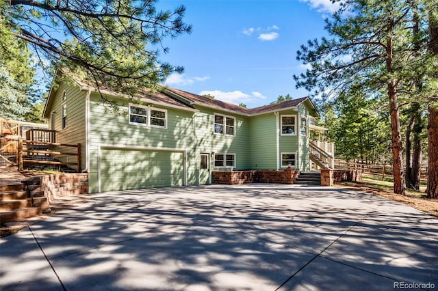 4185 Red Rock Dr, Larkspur, CO 80118 - view of front facade with concrete driveway, a garage, and stairway