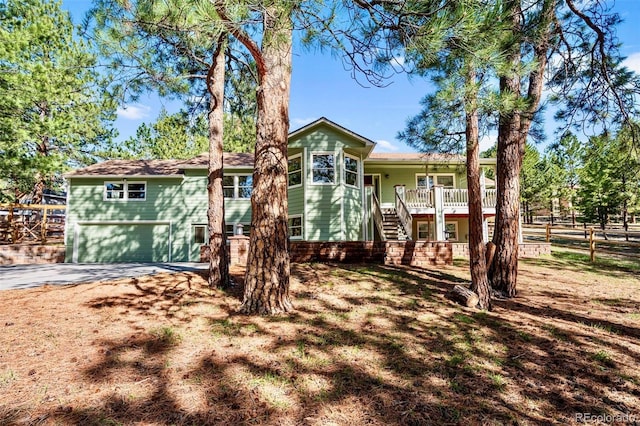 4185 Red Rock Dr, Larkspur, CO 80118 - view of front of home featuring a garage, stairs, fence, and driveway