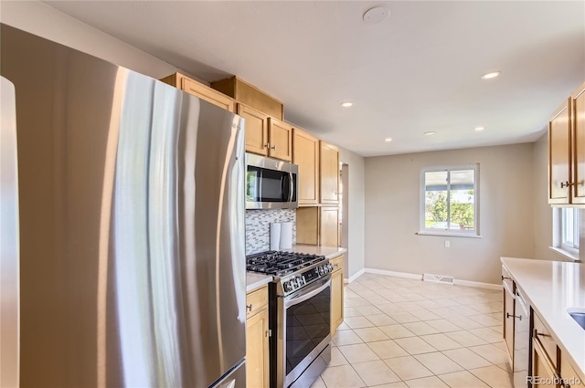 925 Wolff St, Denver, CO 80204 - kitchen featuring appliances with stainless steel finishes, light countertops, backsplash, recessed lighting, and light tile patterned flooring