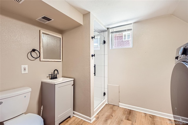 925 Wolff St, Denver, CO 80204 - bathroom with a stall shower, vanity, wood finished floors, and washer / clothes dryer