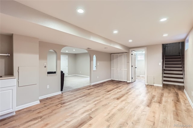 925 Wolff St, Denver, CO 80204 - unfurnished living room with light wood-style flooring, stairway, recessed lighting, and arched walkways