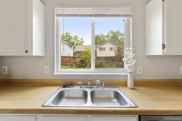kitchen with a sink, light countertops, white cabinetry, and dishwasher