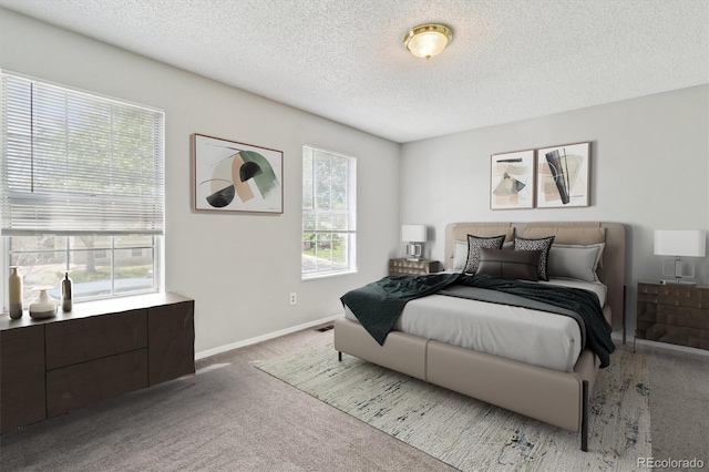 bedroom with carpet, a textured ceiling, and baseboards