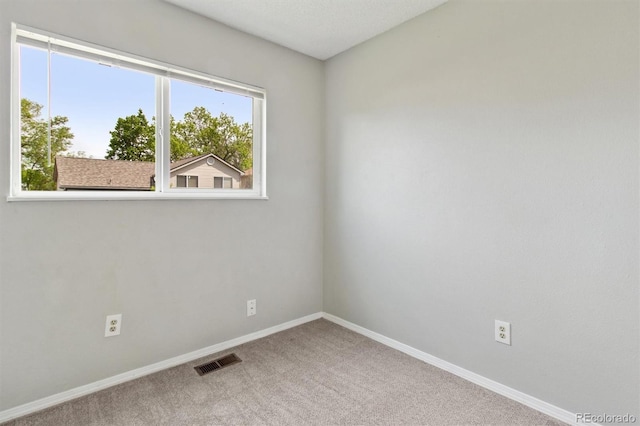 unfurnished room with carpet and baseboards