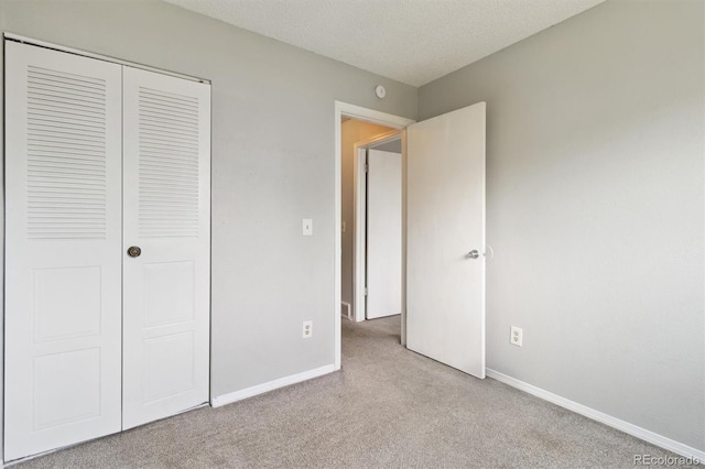 unfurnished bedroom featuring carpet, a closet, and baseboards