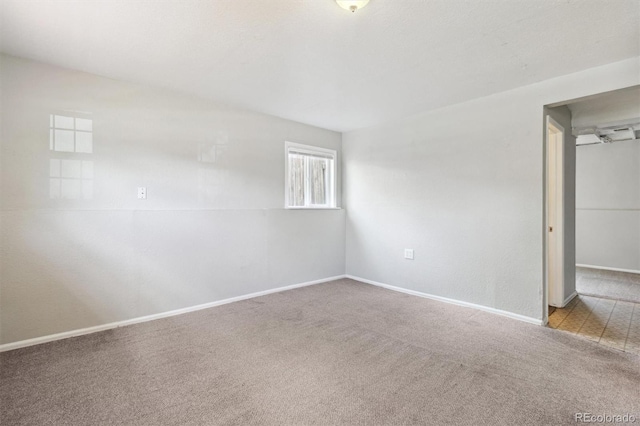 carpeted empty room with baseboards