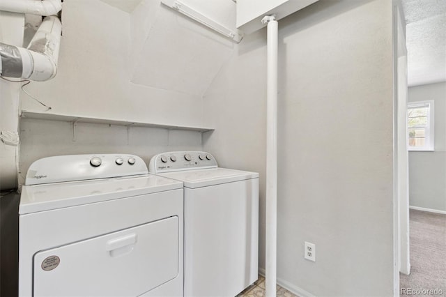 clothes washing area with washer and dryer and baseboards