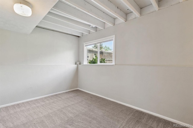 carpeted spare room featuring baseboards and a smoke detector
