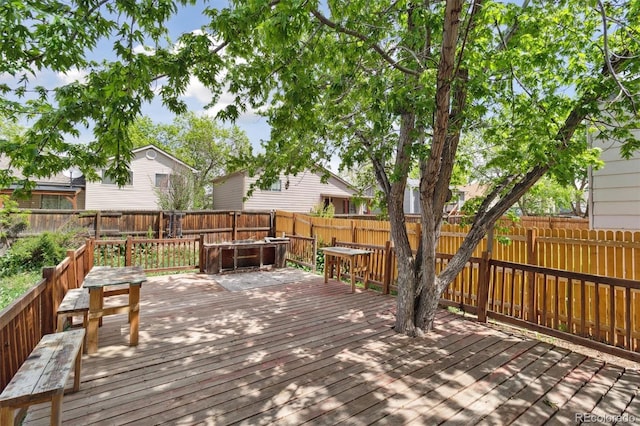 wooden deck with a fenced backyard