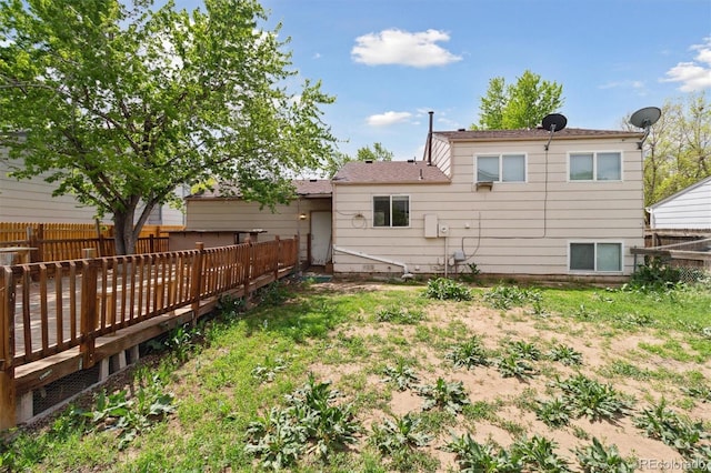 rear view of house featuring a deck and fence