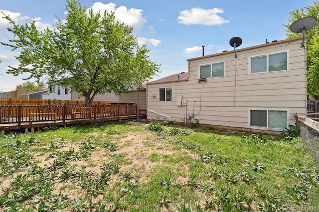 rear view of house featuring a wooden deck and fence