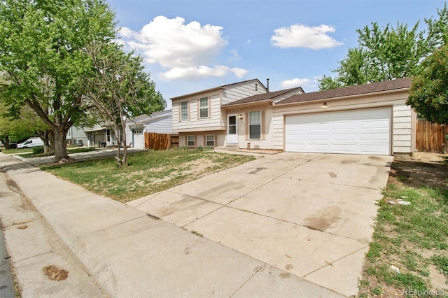 split level home featuring driveway, fence, and an attached garage