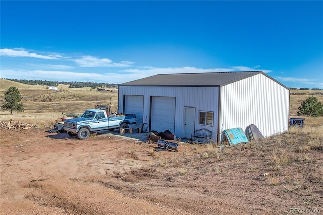 view of outdoor structure with a rural view and a garage