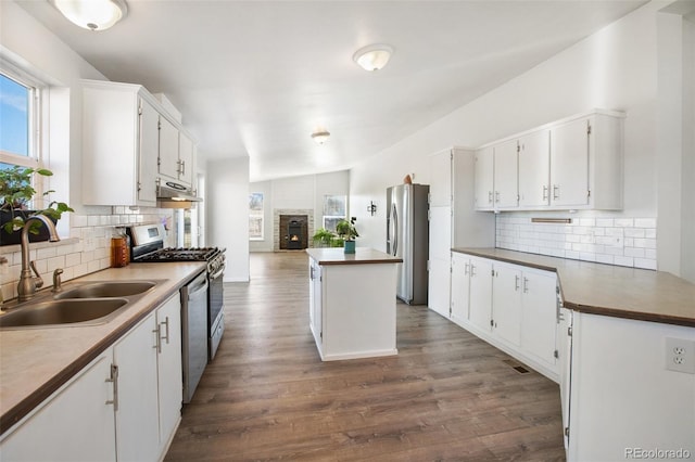 kitchen featuring stainless steel appliances, sink, white cabinetry, dark hardwood / wood-style floors, and a kitchen island