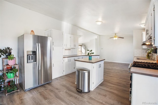 kitchen with white cabinets, sink, stainless steel refrigerator with ice dispenser, tasteful backsplash, and a kitchen island