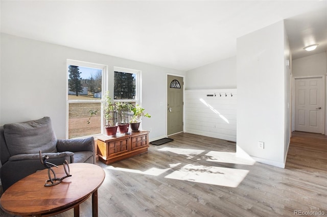 sitting room featuring lofted ceiling and light wood-type flooring