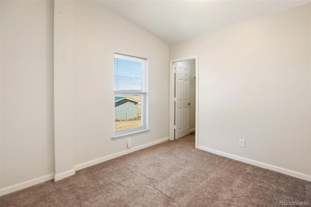 empty room with carpet flooring and vaulted ceiling