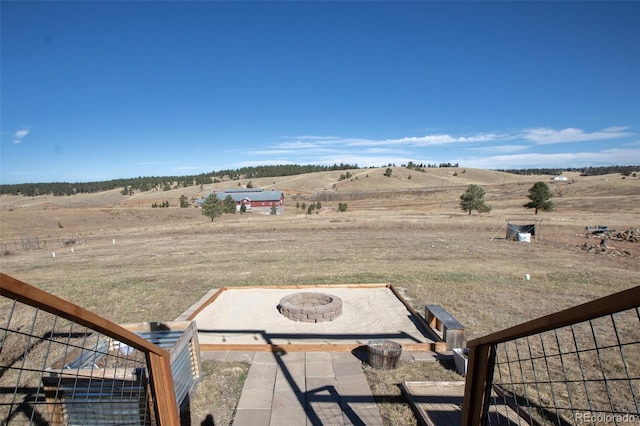 view of yard with a patio, a rural view, and an outdoor fire pit