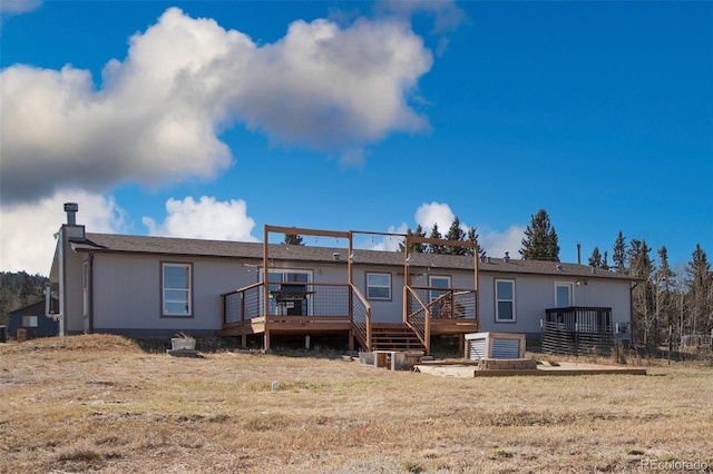 rear view of house featuring a wooden deck