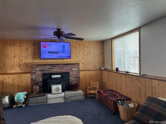 living room with a textured ceiling, wooden walls, carpet, visible vents, and wainscoting