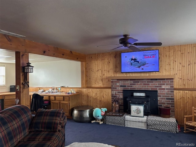 living area with wainscoting, wooden walls, carpet flooring, and a wood stove