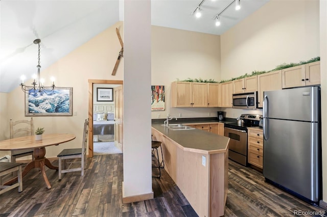 kitchen with high vaulted ceiling, sink, hanging light fixtures, kitchen peninsula, and stainless steel appliances