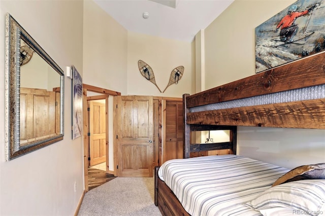 bedroom with carpet floors and a towering ceiling