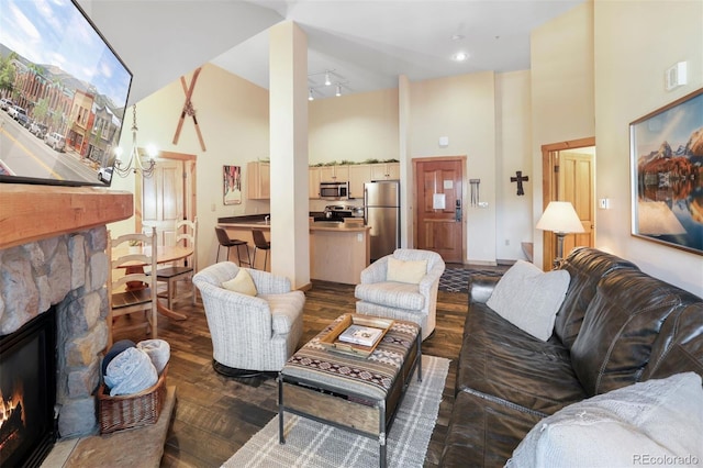 living room featuring dark hardwood / wood-style floors, a fireplace, and a high ceiling