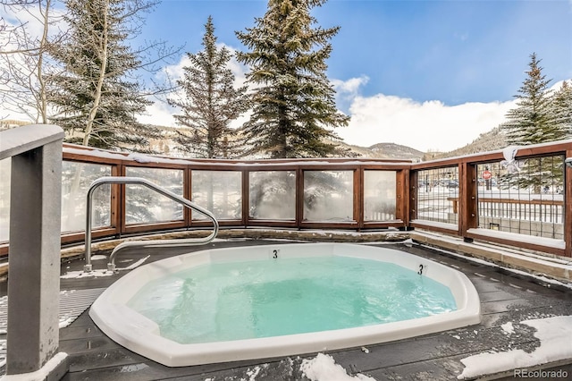 snow covered pool featuring a deck with mountain view