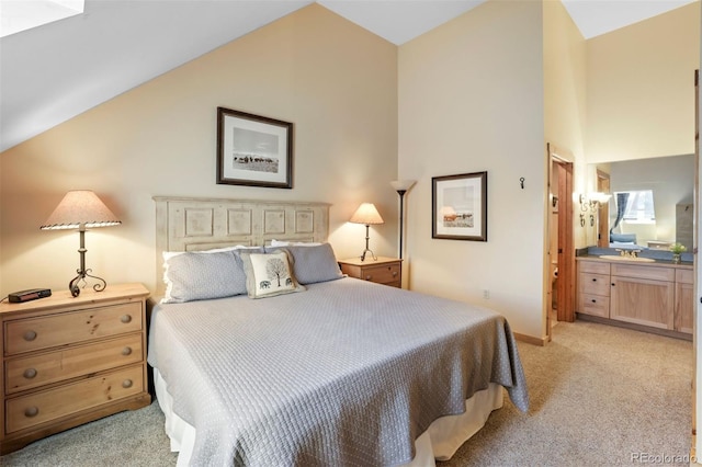 bedroom with light carpet, ensuite bath, and vaulted ceiling
