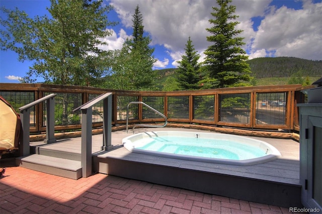 view of pool with an in ground hot tub and a mountain view