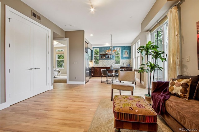 340 S Lafayette St Unit 204, Denver, CO 80209 - living area featuring light wood finished floors, healthy amount of natural light, a chandelier, and recessed lighting