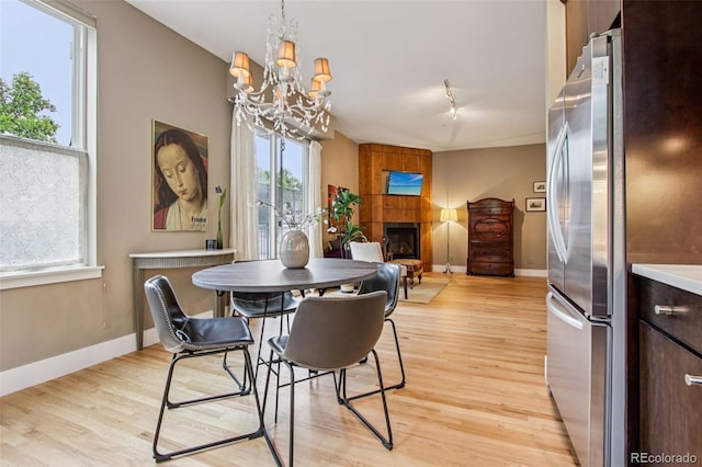 340 S Lafayette St Unit 204, Denver, CO 80209 - dining space with a fireplace, a chandelier, and light wood finished floors
