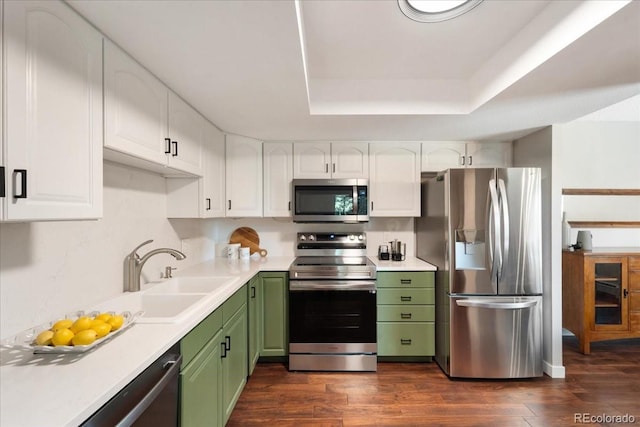 13902 E Marina Dr Unit 202, Aurora, CO 80014 - kitchen featuring appliances with stainless steel finishes, green cabinets, white cabinets, dark wood finished floors, and a tray ceiling