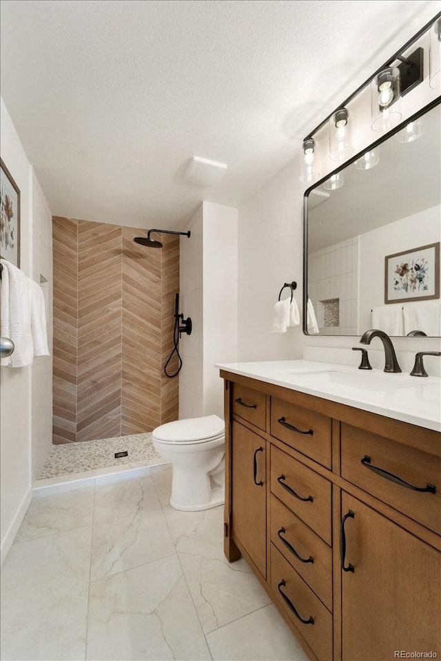13902 E Marina Dr Unit 202, Aurora, CO 80014 - bathroom featuring marble finish floors, tiled shower, vanity, and a textured ceiling