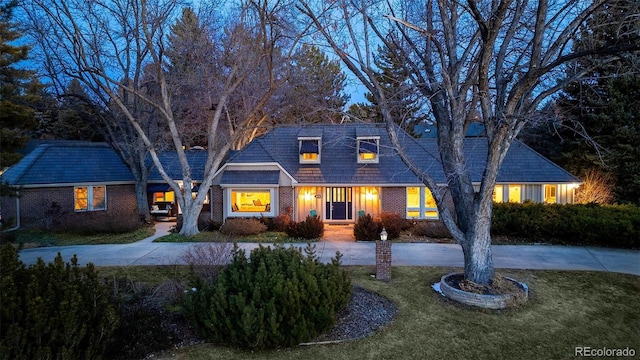 cape cod house with a front lawn