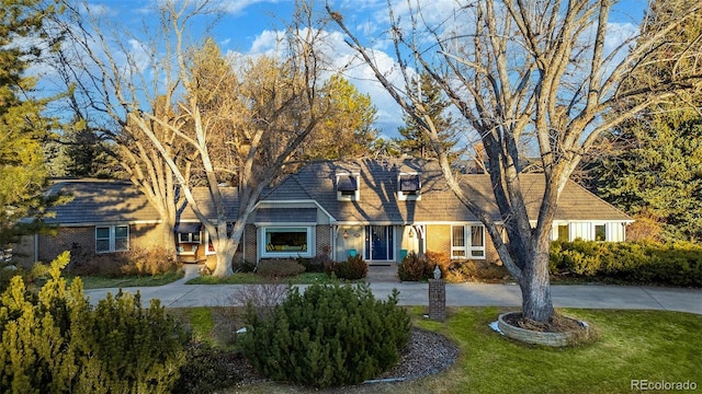 cape cod house featuring a front lawn