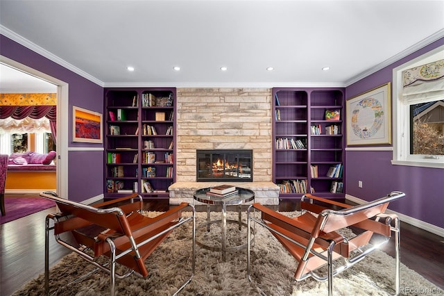 interior space with built in shelves, ornamental molding, a fireplace, and hardwood / wood-style floors