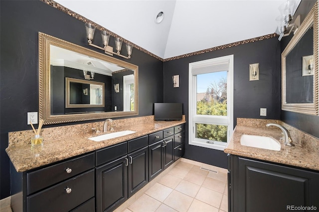 bathroom with tile patterned flooring, vaulted ceiling, and vanity